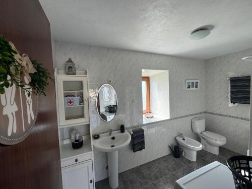 a bathroom with a sink and a toilet and a mirror at A Vixía do Roncudo in Corme-Puerto