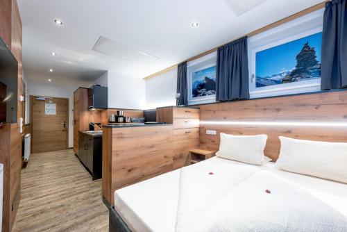 a bedroom with a large white bed and windows at AlpenLiving in Mayrhofen