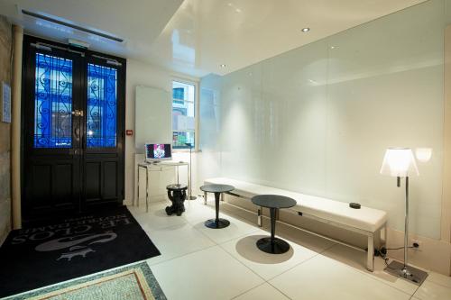 une chambre avec un banc et deux tabourets devant une porte dans l'établissement Hôtel le Clos de Notre Dame, à Paris