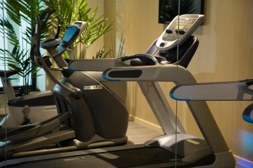 a gym with a treadmill and a phone on it at Hôtel Oceania Le Métropole in Montpellier