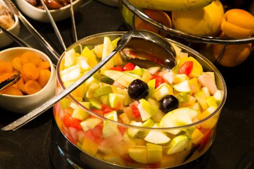 a salad in a bowl with a spoon in it at Hôtel Oceania Le Métropole in Montpellier