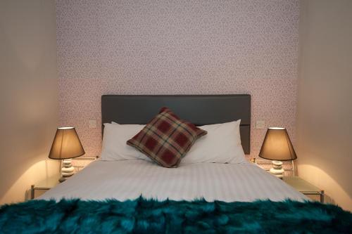 a bedroom with a bed with a pillow and two lamps at The Royal Hotel and Bar in Lancaster