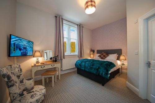 a bedroom with a bed and a desk and a chair at The Royal Hotel and Bar in Lancaster