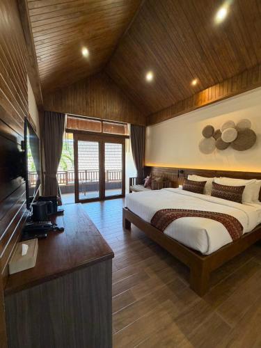a bedroom with a bed and a television in a room at Phi Phi Villa Resort in Phi Phi Islands