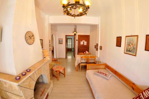 a living room with a fireplace and a chandelier at Alexandros Apartments & Studios in Agios Gordios