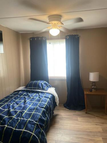 a bedroom with a blue bed and a ceiling fan at Mem's Place in Bluefield