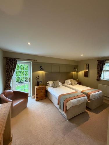 a large bedroom with two beds and a window at New Farm Cheshire B&B in Winsford