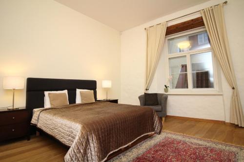 a bedroom with a bed and a window and a chair at Tallinn City Apartments Old Town Toompea in Tallinn