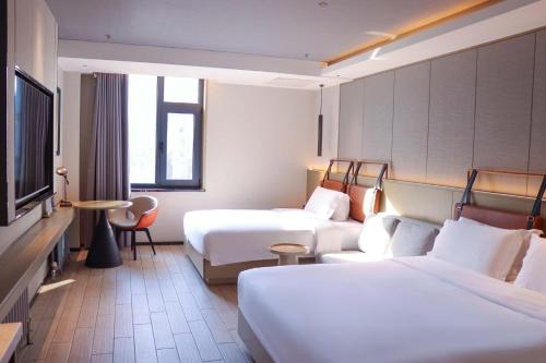a hotel room with two beds and a flat screen tv at Yilan Yunjing Boutique Hotel in Beijing