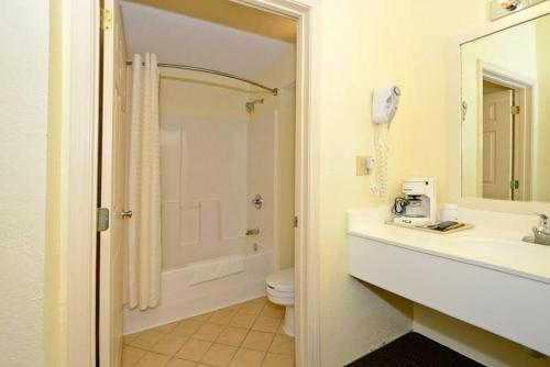une salle de bain avec un lavabo, des toilettes et une douche dans l'établissement Manchester Heritage Inn & Suites, à Manchester