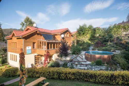 una casa de madera con piscina en el patio en Penzión Pod Guglom, en Mlynky 