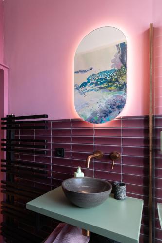 ein Badezimmer mit Waschbecken und Spiegel in der Unterkunft B&B d'Ouwe Grutter in Wagenberg