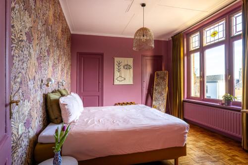 ein lila Schlafzimmer mit einem Bett und einem Fenster in der Unterkunft B&B d'Ouwe Grutter in Wagenberg