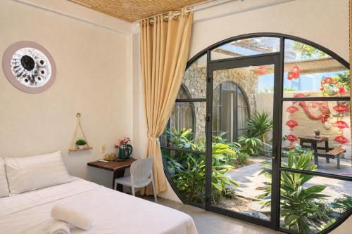 a bedroom with a bed and a large window at Tròn Homestay Vĩnh Hy in Vĩnh Hy