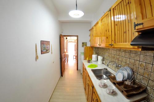 a kitchen with wooden cabinets and a sink at Alexandros Apartments & Studios in Agios Gordios