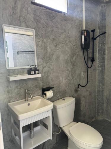 a bathroom with a white toilet and a sink at The cozy house in Trang
