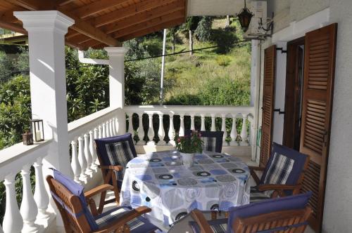 a table and chairs on a porch at Alexandros Apartments & Studios in Agios Gordios