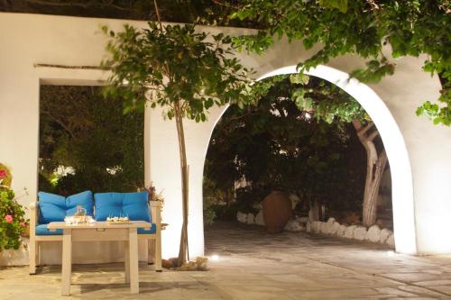 a patio with a blue couch and a table at Naxian Queen Luxury Villas & Suites in Agia Anna Naxos