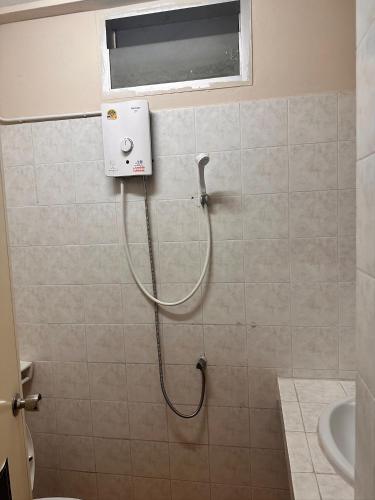 a shower in a bathroom with a hose on the wall at Nana's Apartment in Pattaya