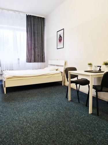 a bedroom with a bed and a table and chairs at mHostel24 in Lublin