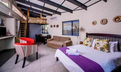 a bedroom with a bed and a living room at Zebrina Guest House in Nelspruit