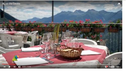 a table with a red table cloth and glasses on it at Da Cecilia in Bognanco