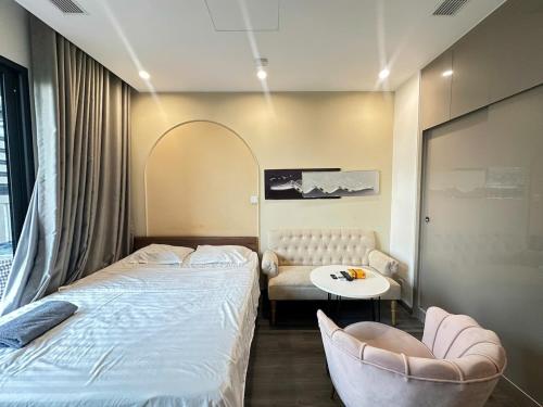 a bedroom with a bed and a chair and a table at R1 Studio Ruby Zenpark in Gia Lâm Pho