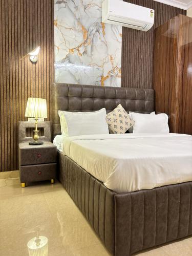 a bedroom with a large bed and a table with a lamp at Hotel Fortune Home Residency Near Spectrum Mall Sector 72 in Noida