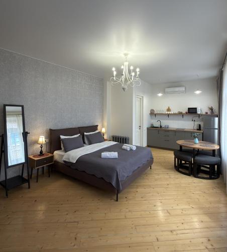 a bedroom with a large bed and a chandelier at Old Gold Anteon in Tbilisi City