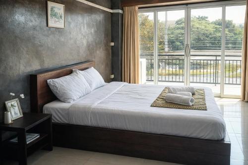 a bedroom with a bed and a large window at B&T Hostel in Ban Pa Tung (7)