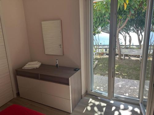 a room with a vanity with a mirror and a window at Le Case di Concetta in Santa Maria