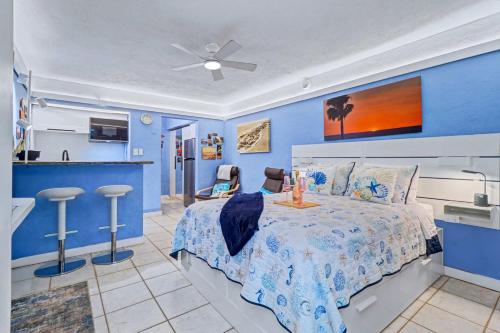 a blue bedroom with a bed and a kitchen at Pass-A-Grille Beach Retreat Unit 8 in St. Pete Beach