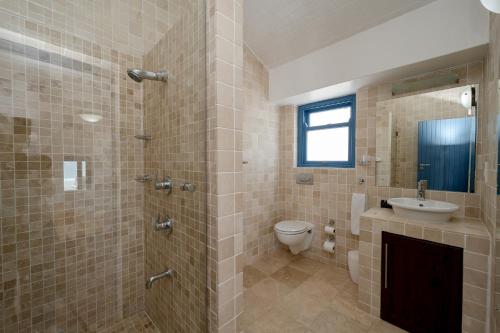 a bathroom with a shower and a toilet and a sink at Seehuis Studios in Langebaan