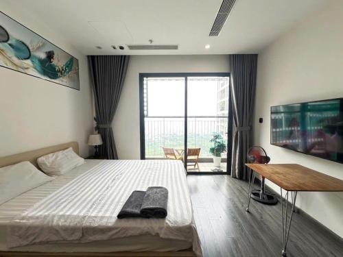 a bedroom with a bed and a desk and a window at R1 Studio Ruby Zenpark in Gia Lâm Pho
