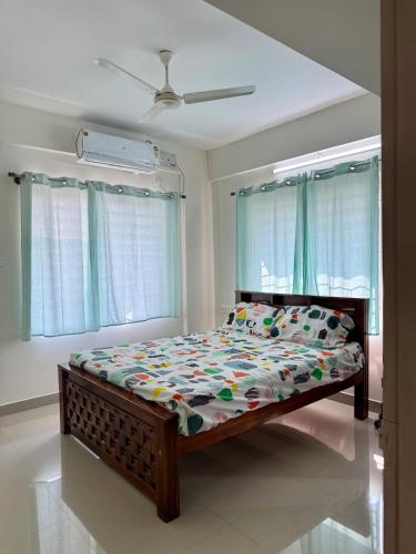 a bedroom with a bed in a room with windows at Between Tides nd Toasts Udupi Manipal in Manipal