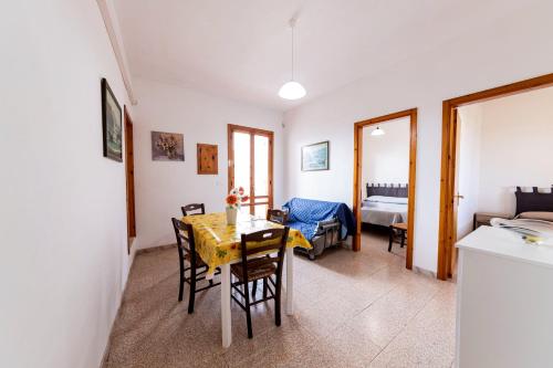 a dining room with a table and chairs and a bedroom at Summer Flat - San Foca in San Foca
