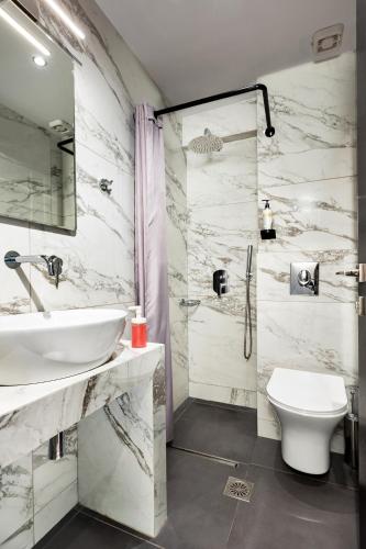 a bathroom with a sink and a toilet and a shower at Minavra Hotel in Athens