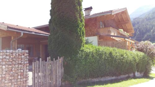 a house with a hedge in front of a building at Gästehaus Reichholf in Neukirchen am Großvenediger