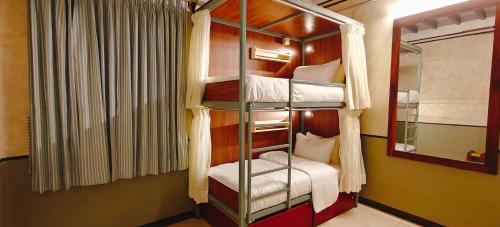 a room with three bunk beds with a mirror at Maison Monty in Pondicherry