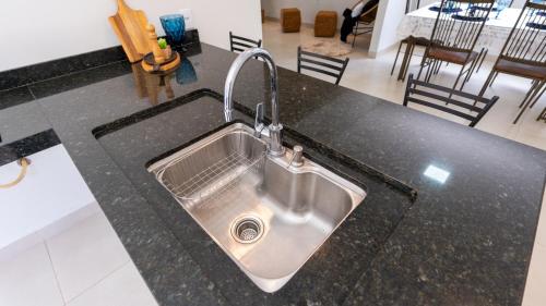 a kitchen sink with a faucet on a counter at Jahu Center Casas Un 5 in Jaú