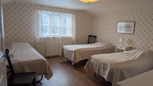 a room with two beds and a window at Kauppilan Matkailutalo in Ikaalinen