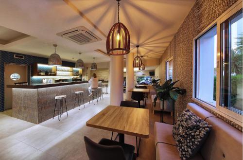 a restaurant with a table and a bar at Agua Hotels Vila Branca in Lagos