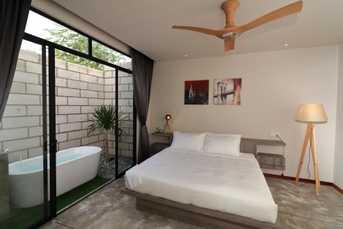 a bedroom with a bed and a bath tub at Laman Sentosa Boutique Residence in Kuantan