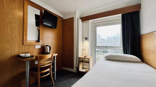 a hotel room with a bed and a window at West Cromwell Hotel in London