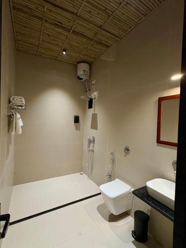 a bathroom with a shower and a toilet and a sink at Jalsa Jawai Resort in Bīsalpur