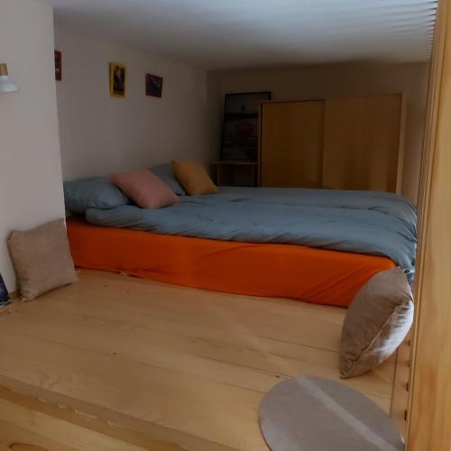 a bedroom with a bed with an orange mattress at ArtCenterApartment in Novi Sad