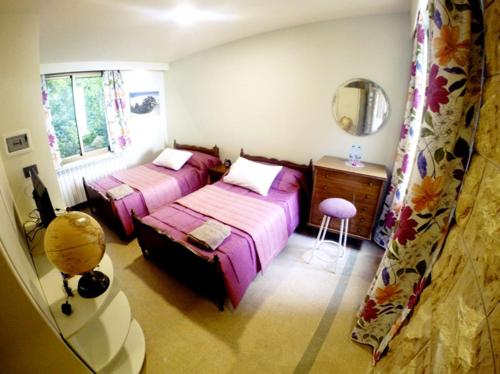 a bedroom with two beds and a desk and a mirror at Beit Wadih in Ghazīr