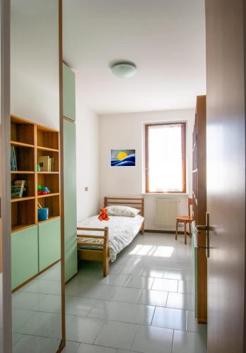 a bedroom with a bed and a window at La casa di a-mici in Maccagno Superiore
