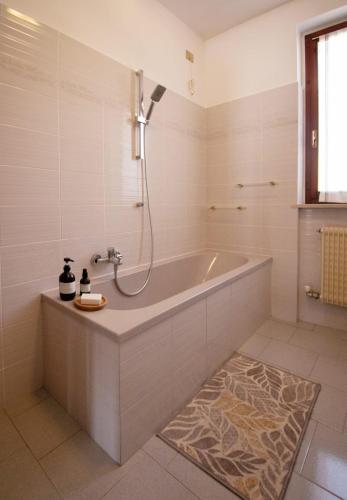a white bathroom with a tub and a shower at La casa di a-mici in Maccagno Superiore