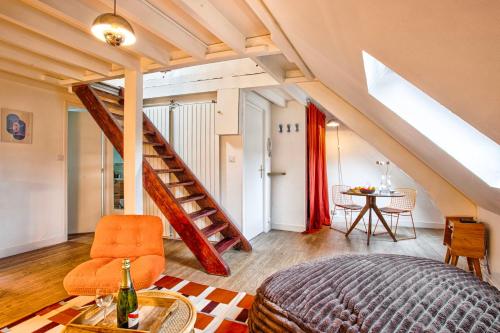 a bedroom with an orange chair and a staircase at La Cime - Duplex hypercentre, Wi-Fi & restaurant in Caen
